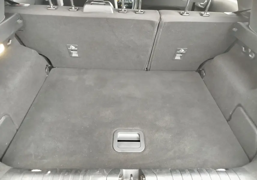 Coffre ouvert vu de l'arrière d'un Ford Puma gris, montrant un espace de chargement propre et bien agencé.