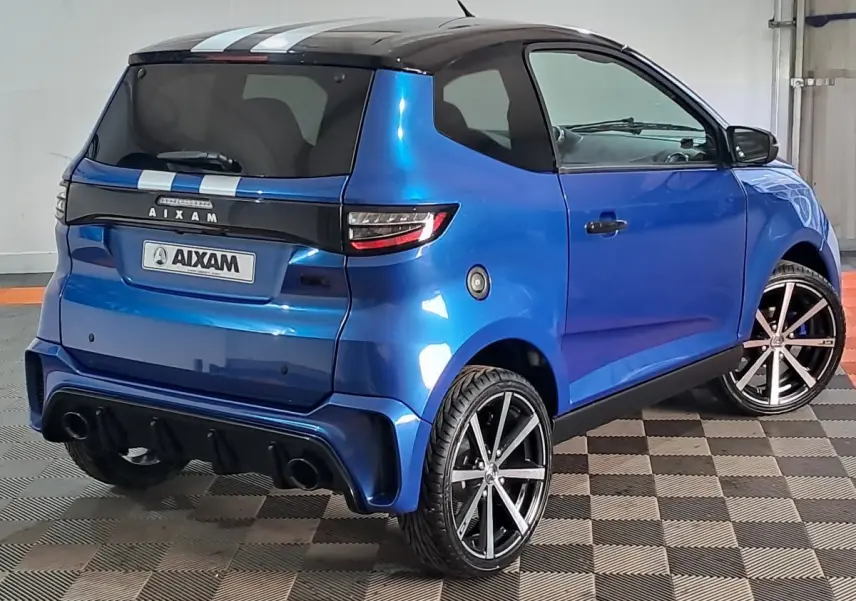 Vue 3/4 arrière droite de l'AIXAM AMBITION bleu 2026 avec jantes noires et bandes blanches sur le toit.