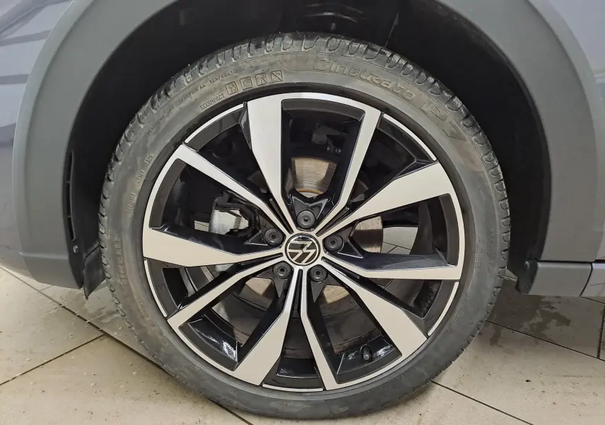 Gros plan sur la jante alliage 18 pouces bicolore noir et argent du Volkswagen Taigo gris cendré, version R-Line Edition.