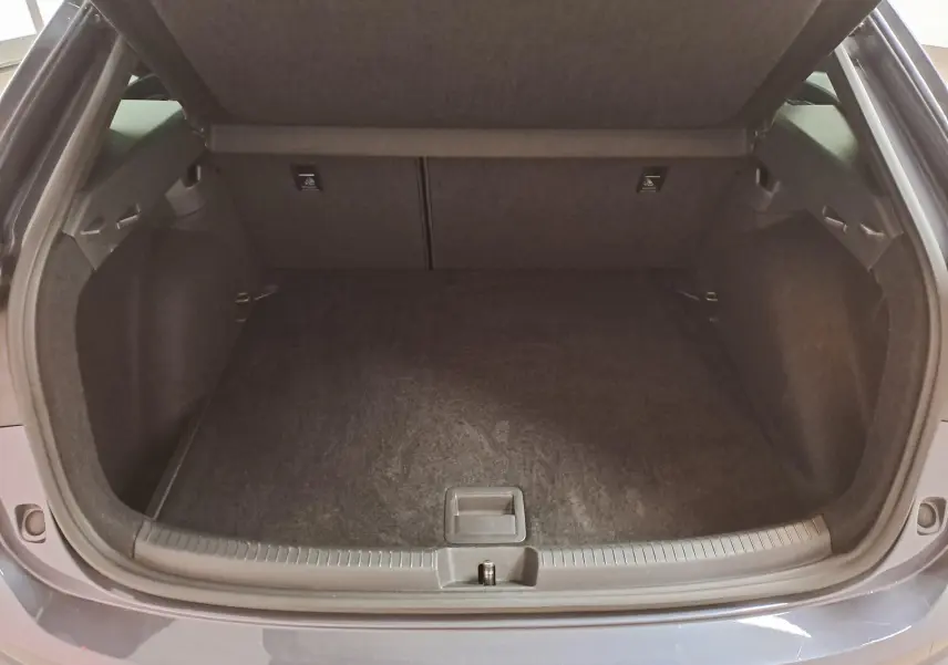 Coffre ouvert vu de l'arrière d'un Volkswagen Taigo gris cendré 2025, finition R-Line avec intérieur noir.