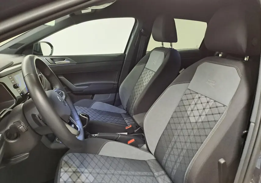 Vue intérieure côté conducteur du Volkswagen Taigo 1.5 TSI R-Line 2025, sièges tissu et alcantara avec logo R brodé.