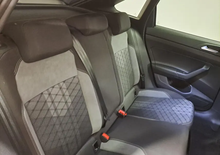 Vue intérieure côté droit des sièges arrière en tissu gris et alcantara avec surpiqûres blanches du Volkswagen Taigo 2025.