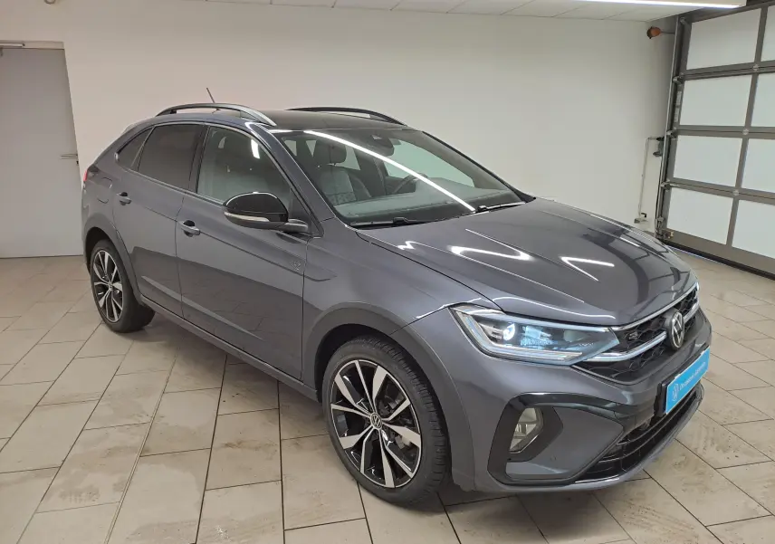 Volkswagen Taigo 1.5 TSI R-Line gris cendré, vue 3/4 avant droit, toit noir et jantes alliage 18 pouces.