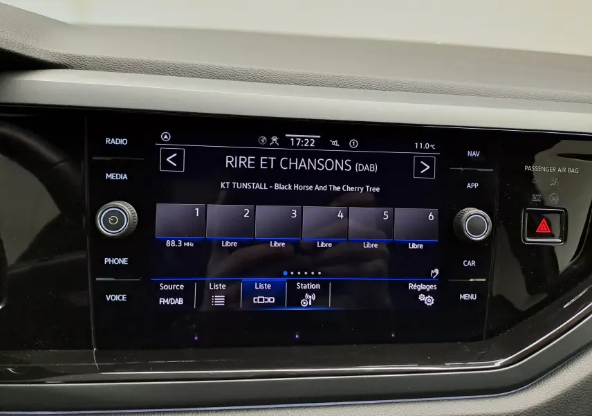 Affichage central tactile du tableau de bord du Volkswagen Taigo 2025, avec interface radio numérique et commandes autour de l'écran.