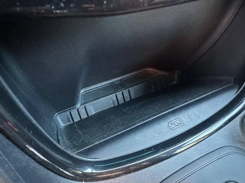 Détail de la console centrale du Ford Puma 2024, zone de rangement noire avec surface antidérapante et symbole de charge sans fil.