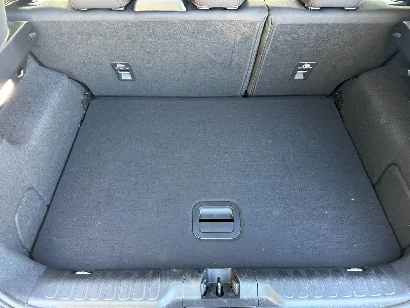 Vue plongeante sur le coffre spacieux et propre du Ford Puma 2024 gris Solar Métallisé, avec banquette arrière rabattue.