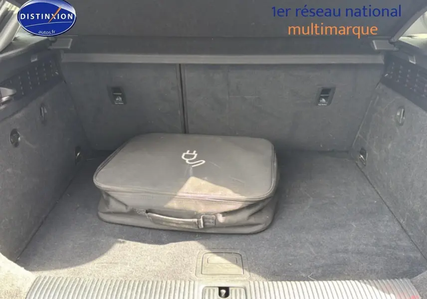 Coffre ouvert d’Audi A3 Sportback noir 2020 avec sac de chargeur hybride posé au centre.