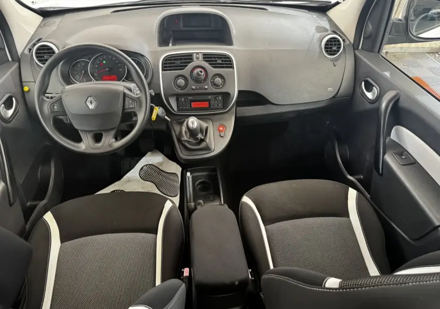 Vue intérieure avant du Renault Kangoo 2016 avec tableau de bord gris, volant multifonctions et sièges noirs à bandes claires.
