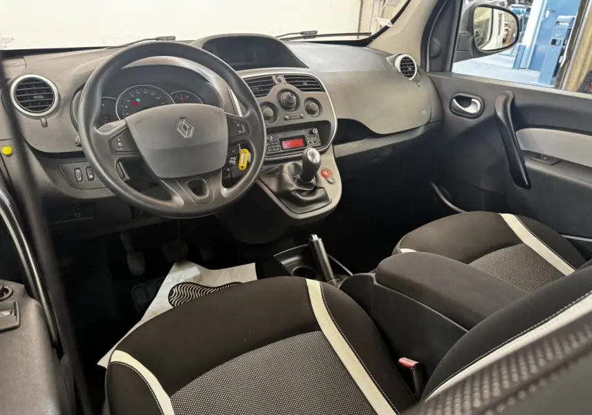 Vue intérieure avant droite du Renault Kangoo 2016 Zen Energy dCi, tableau de bord noir avec volant multifonctions et sièges tissu bicolore.