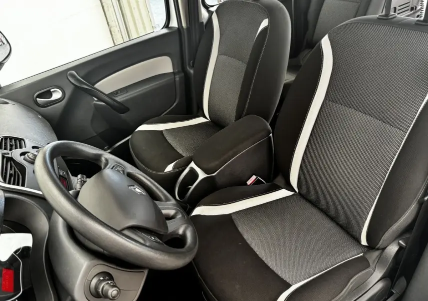 Vue intérieure avant droite du Renault Kangoo 2016, sièges noirs avec bandes blanches et volant multifonctions.