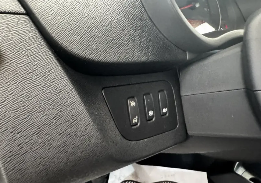 Détail des commandes situées à gauche du volant dans l'habitacle noir du Renault Kangoo Zen 2016.