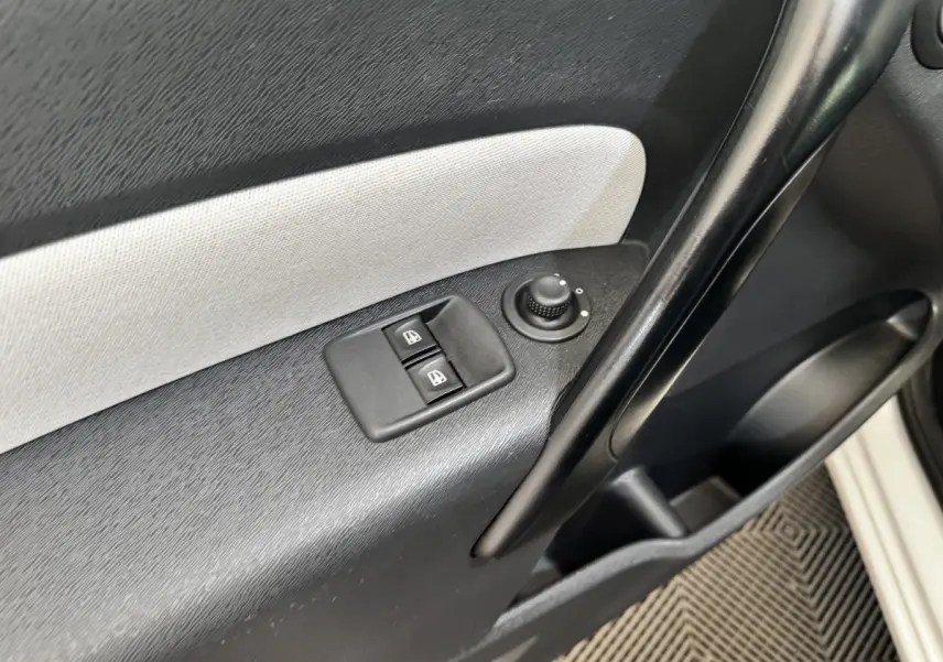 Détail de la porte côté conducteur du Renault Kangoo blanc 2016, avec commandes électriques des vitres et réglage des rétroviseurs.