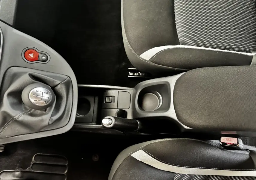 Vue plongeante sur la console centrale et les sièges noirs avec surpiqûres grises du Renault Kangoo Zen 2016.