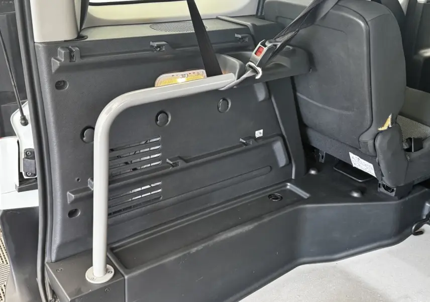 Vue intérieure arrière droite du Renault Kangoo blanc 2016, montrant la banquette et les fixations Isofix.