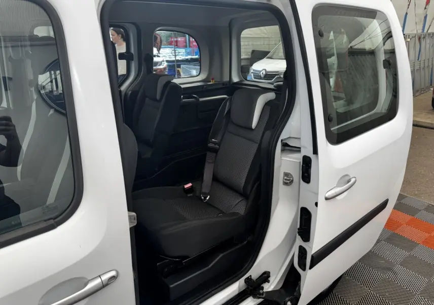 Vue latérale droite du Renault Kangoo blanc 2016 avec porte coulissante ouverte et siège arrière visible.