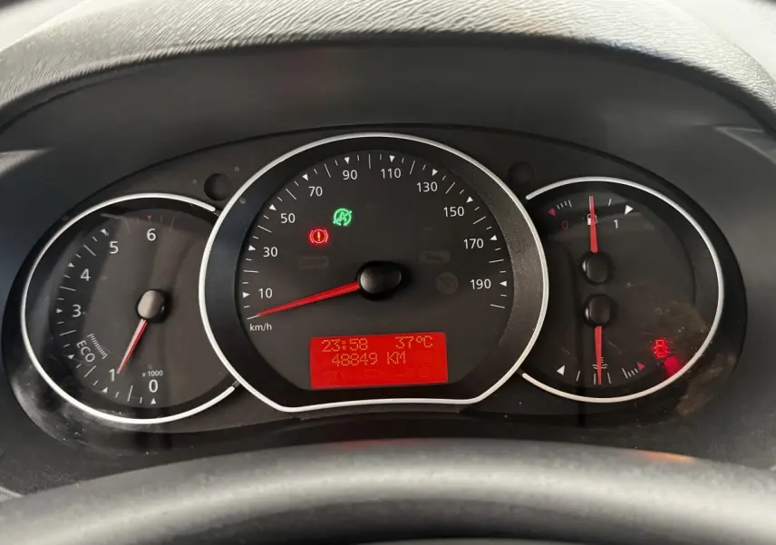 Vue rapprochée du tableau de bord du Renault Kangoo blanc 2016, affichant le compteur et les voyants allumés.