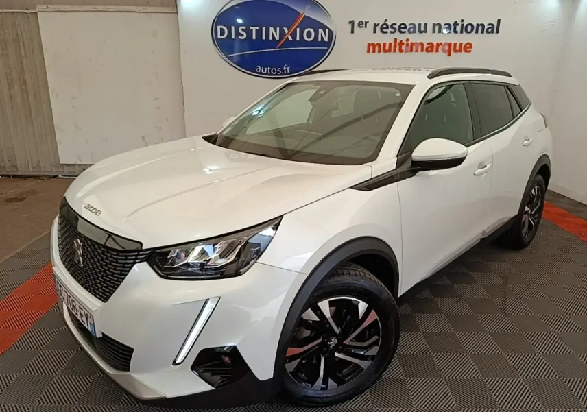 Peugeot 2008 blanc en 3/4 avant droit, avec jantes noires et toit noir dans un showroom intérieur.