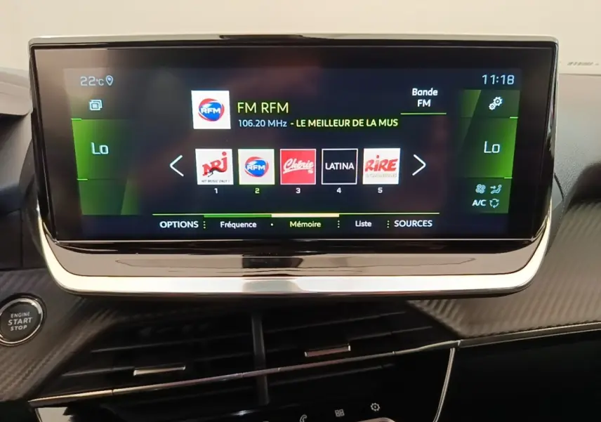 Écran tactile central de 10 pouces du Peugeot 2008 blanc, affichant la radio FM avec commandes intégrées.