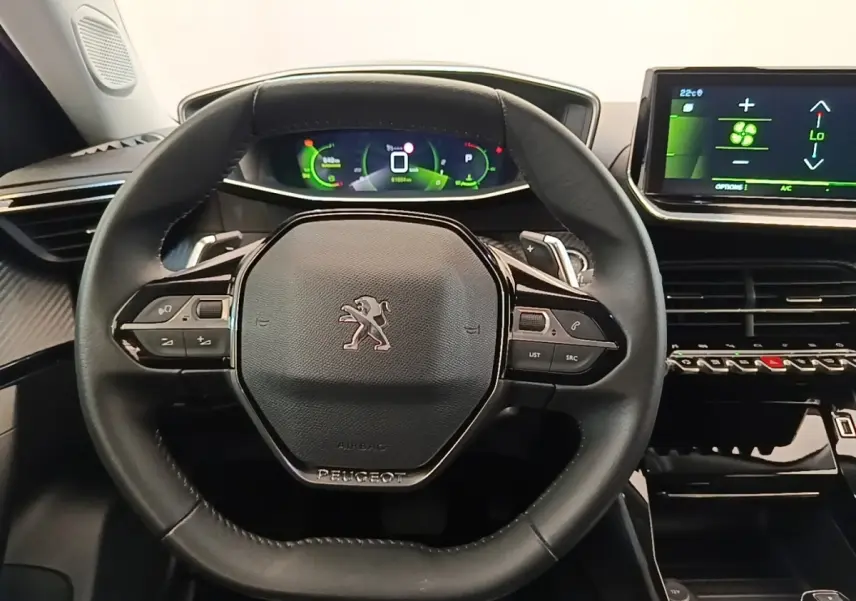Vue rapprochée du volant cuir multifonctions noir du Peugeot 2008 avec tableau de bord numérique et écran tactile central.