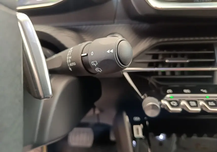 Gros plan sur la commande des essuie-glaces dans l’habitacle noir du Peugeot 2008 diesel blanc, version 2021.