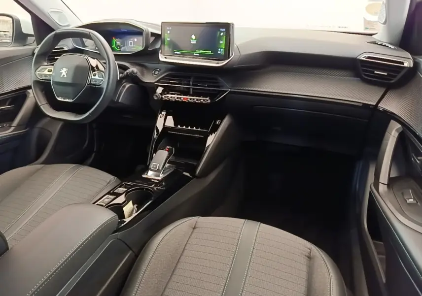 Intérieur noir et gris du Peugeot 2008 2021, vue de face côté conducteur avec volant cuir et écran tactile central.