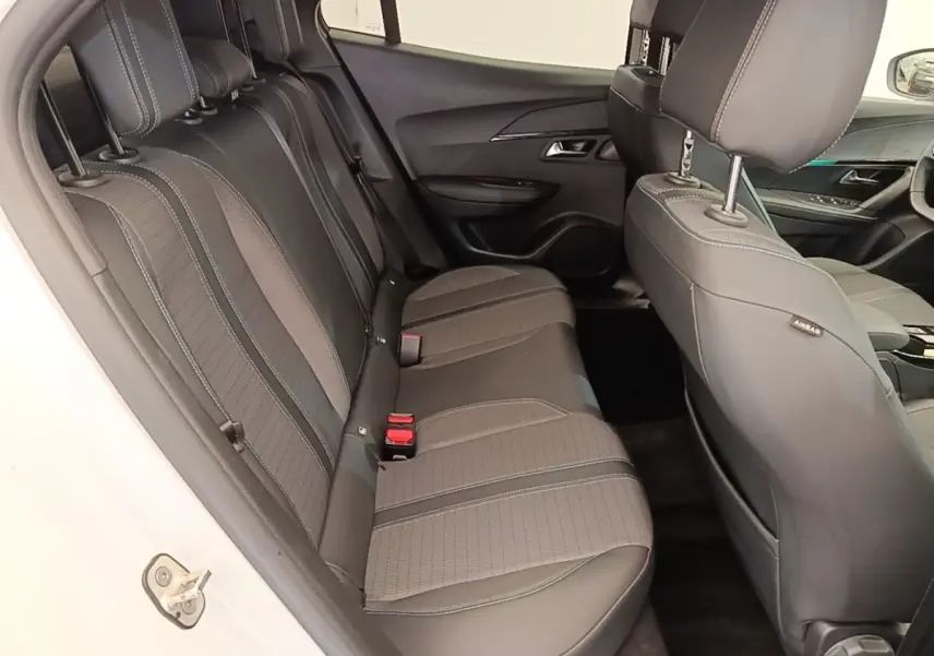 Vue intérieure côté gauche montrant la banquette arrière noire du Peugeot 2008 blanc de 2021 avec finitions tissu et cuir.
