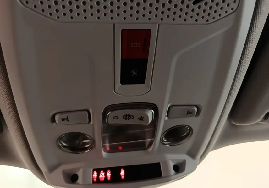 Vue en gros plan du plafonnier intérieur gris clair avec boutons de lumière et alerte SOS du Peugeot 2008 blanc de 2021.