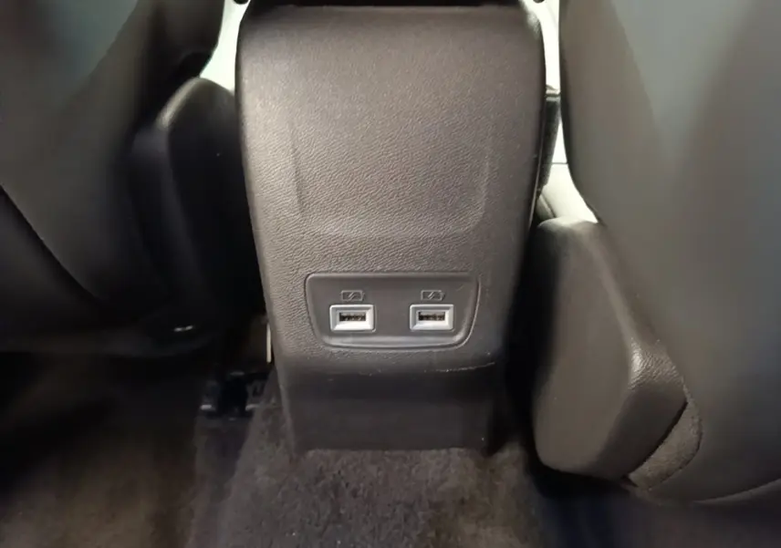 Prise double USB noire vue de face entre les sièges arrière d’un Peugeot 2008 blanc.
