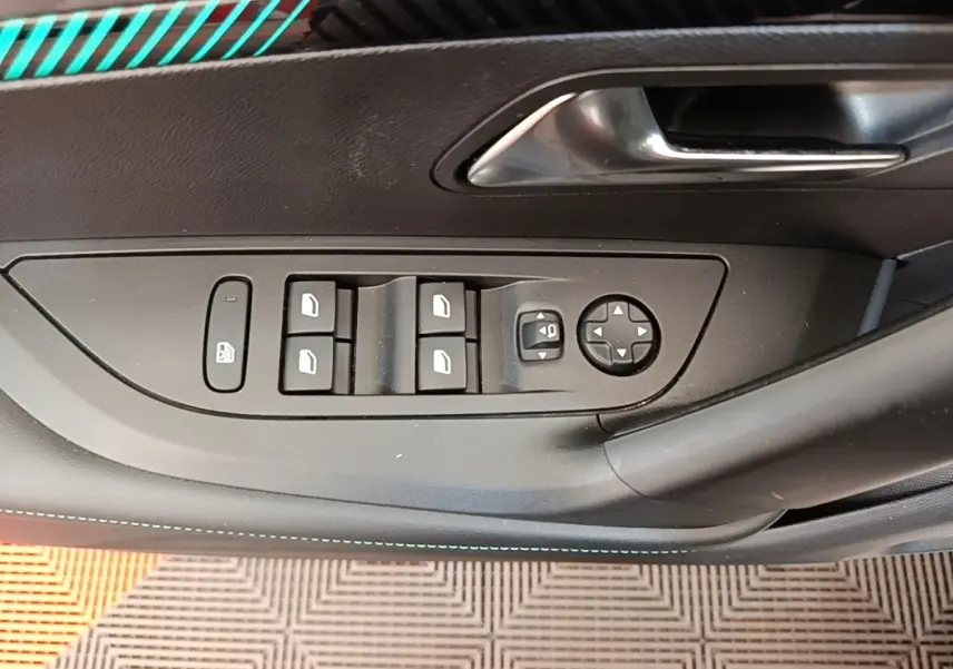 Vue rapprochée de la porte côté conducteur d'une Peugeot 2008 blanche, avec commandes électriques des vitres et rétroviseurs.