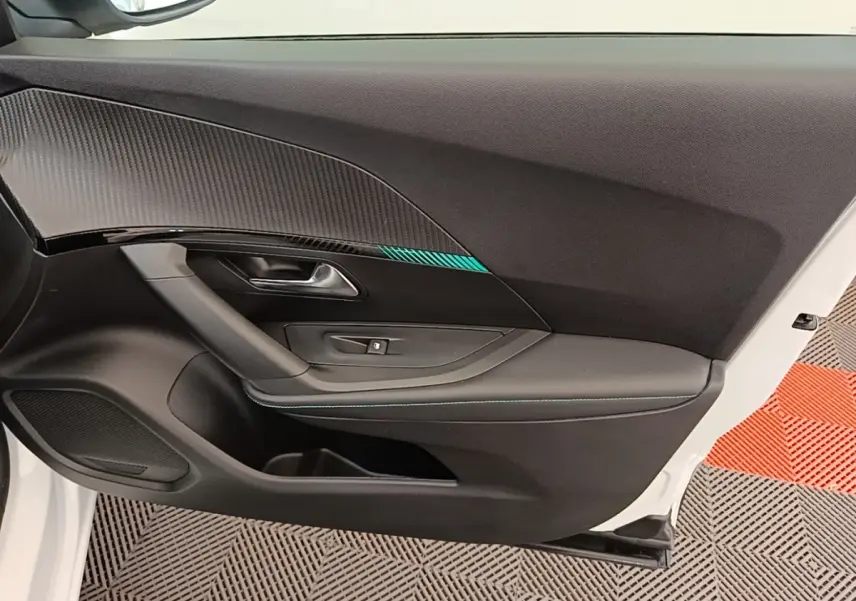Vue intérieure de la porte avant gauche blanche du Peugeot 2008 avec insert décoratif noir et bleu.