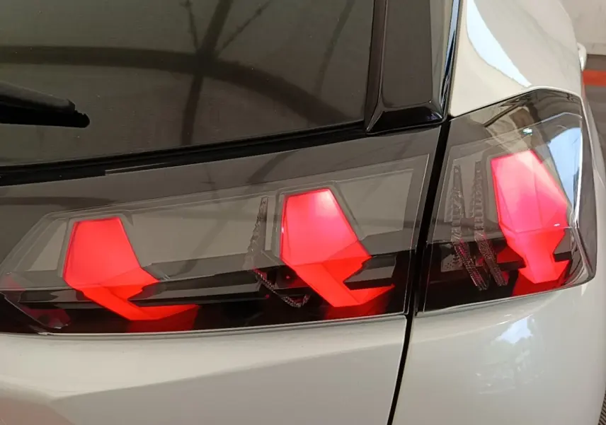 Gros plan sur les feux arrière rouges du Peugeot 2008 blanc, vue du côté droit arrière du véhicule.