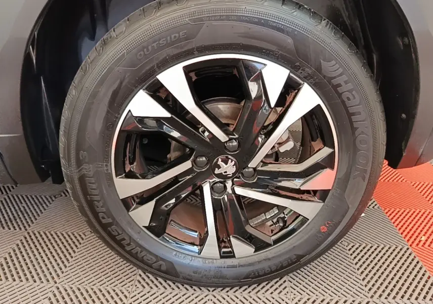 Gros plan sur la jante alliage noire et argentée avec logo Peugeot, montée sur pneu Hankook Ventus Prime 3.