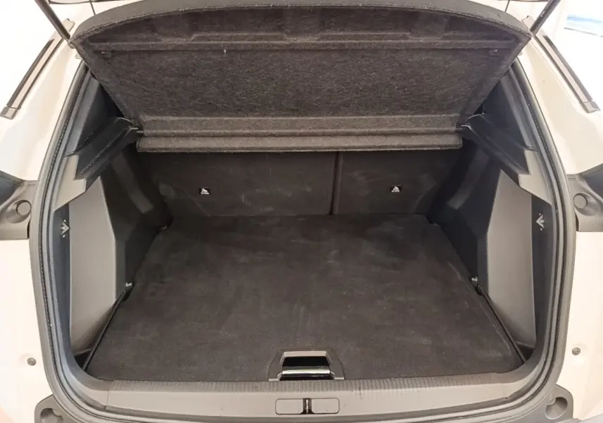 Coffre ouvert vu de l’arrière d’un Peugeot 2008 blanc, montrant un espace de chargement propre et spacieux.