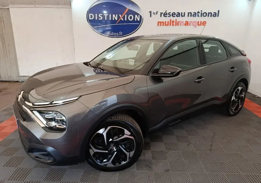 Citroën C4 gris clair vue 3/4 avant droit, avec jantes noires et design moderne des phares LED.