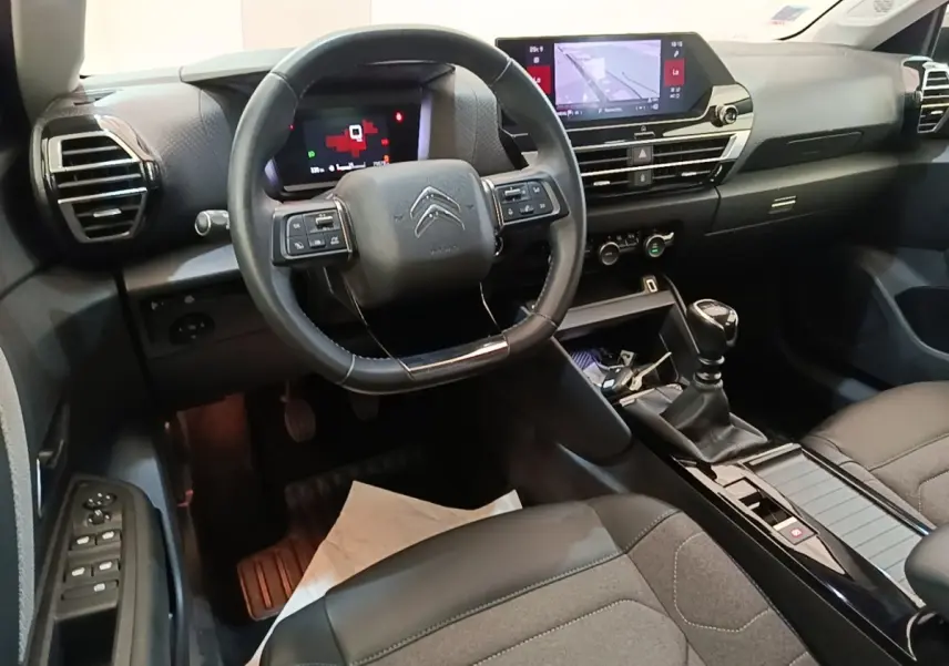 Vue intérieure de face du poste de conduite de la Citroën C4 2021 avec volant cuir et écran tactile central.