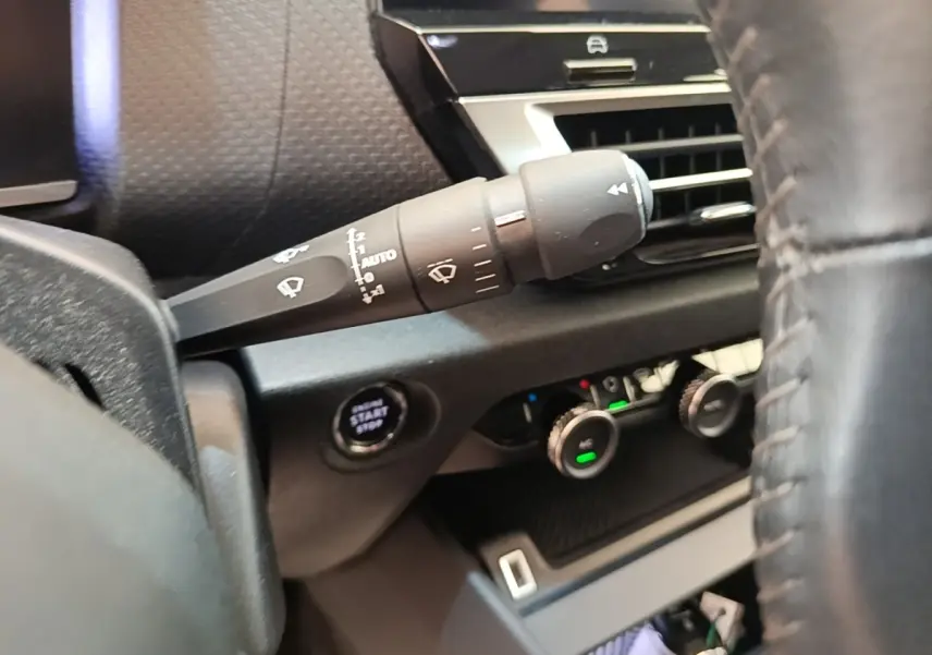 Gros plan sur la commande d’essuie-glace et le bouton start/stop côté gauche du tableau de bord d’une Citroën C4 gris clair.