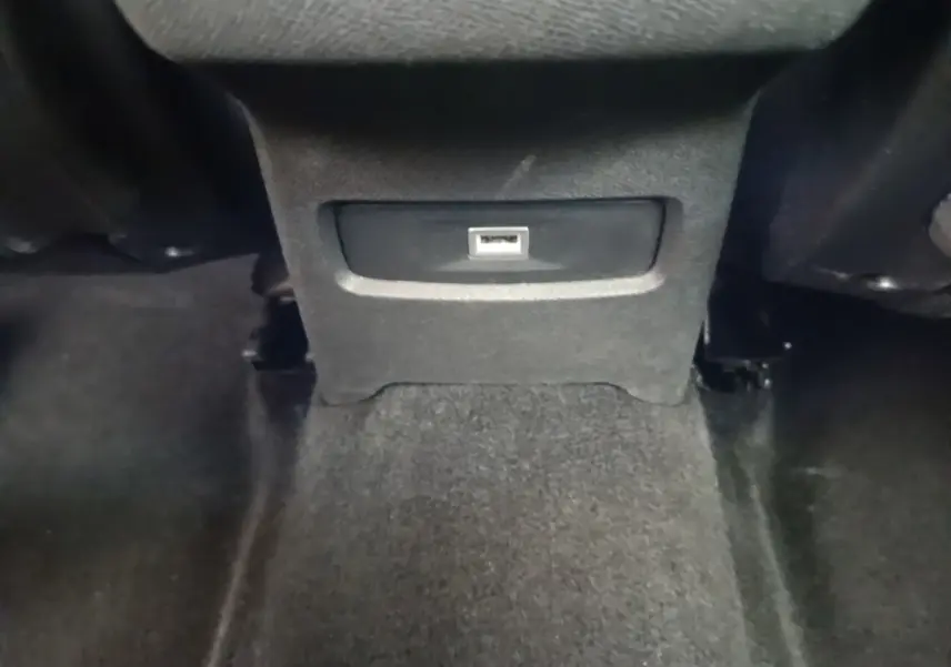 Prise USB arrière centrale dans l’habitacle noir d’une Citroën C4 PureTech 130 essence 2021.