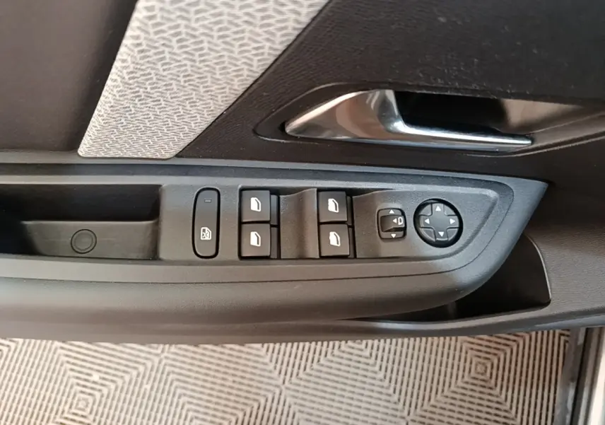 Vue rapprochée de la porte côté gauche de la Citroën C4 2021, avec commandes des vitres et rétroviseurs.