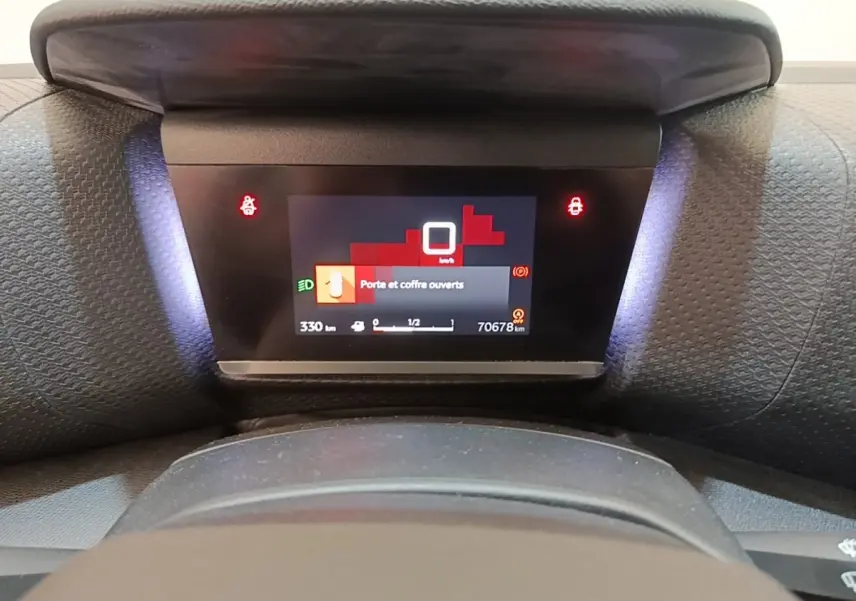Tableau de bord numérique de Citroën C4 gris clair, affichant l'alerte porte et coffre ouverts.
