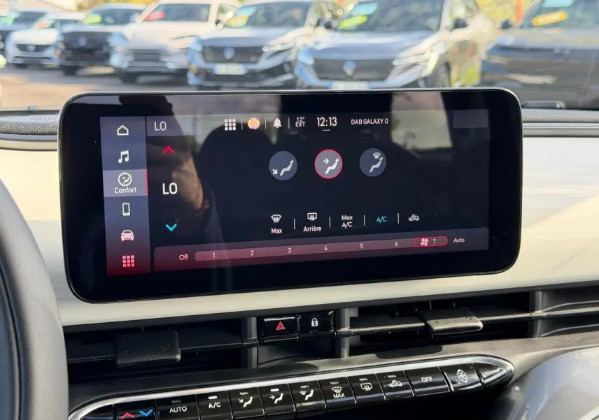 Gros plan sur l'écran tactile central et la console de la Fiat 500 e 118ch Ice White pastel, intérieur moderne et épuré.