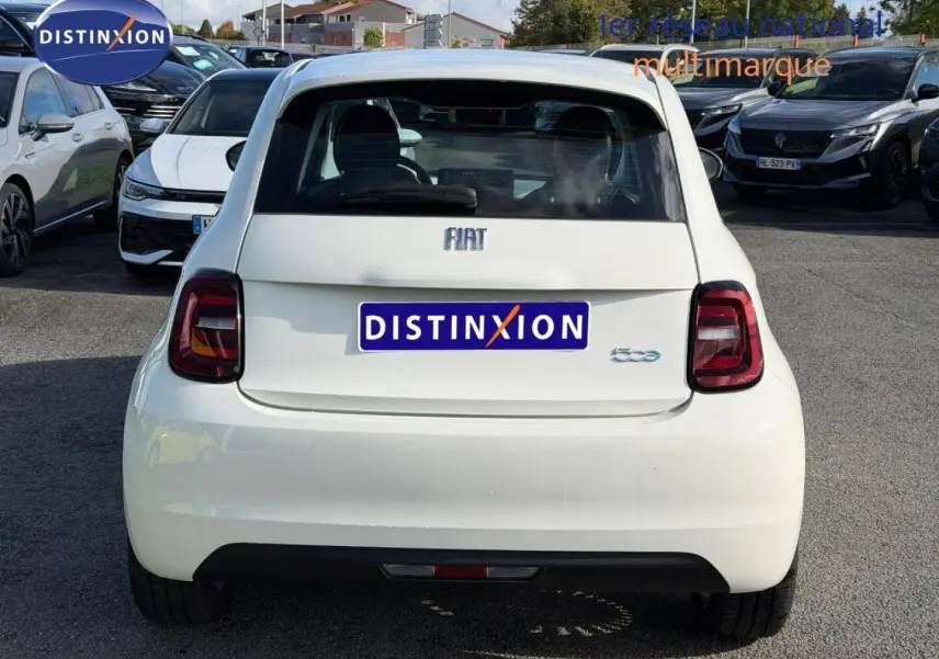 Vue arrière d'une FIAT 500 électrique Ice White pastel 2024, avec feux arrière LED et becquet distinctif.
