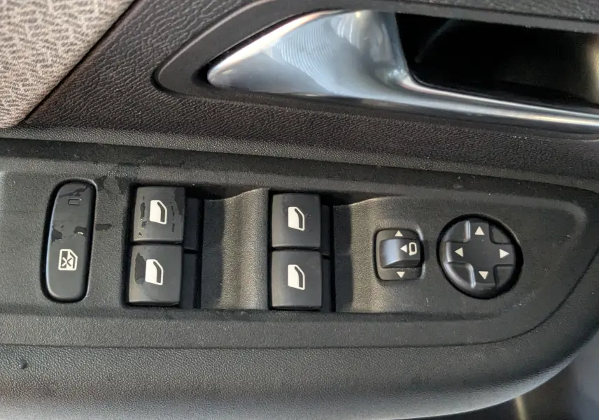 Panneau de commandes des vitres et rétroviseurs côté conducteur dans une Citroën C4 gris platinium 2024.