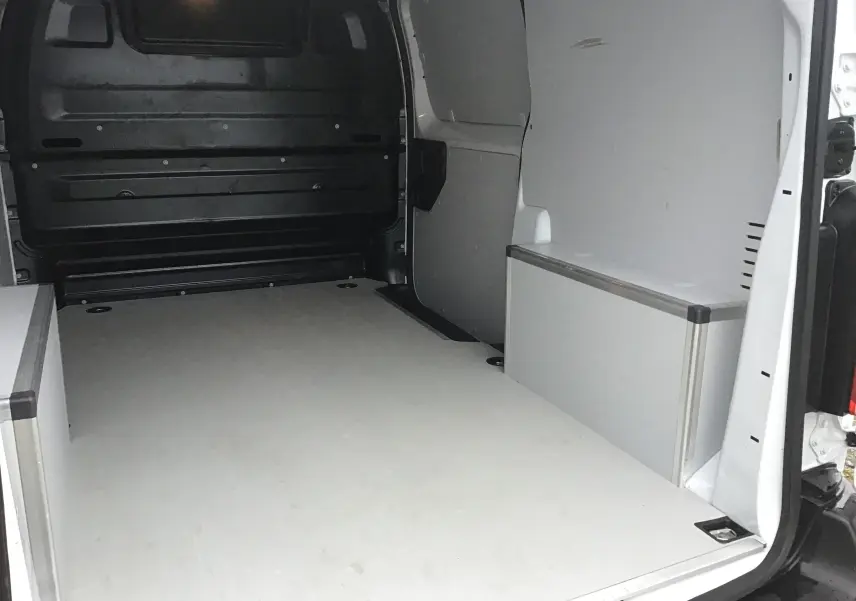 Vue intérieure arrière du fourgon FIAT Scudo blanc, montrant l'espace de chargement avec aménagements latéraux en bois clair.