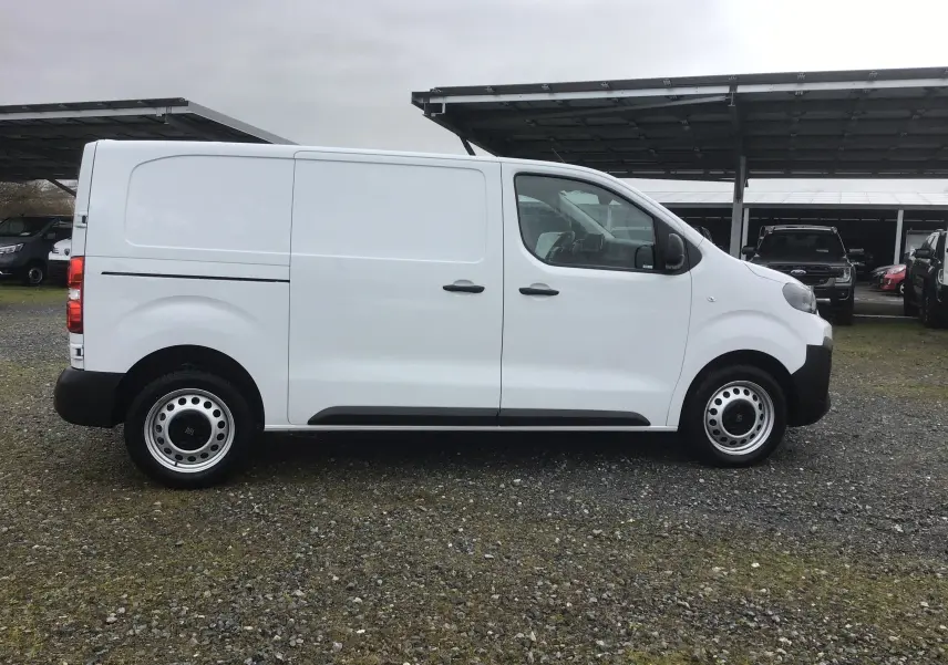 Vue de profil côté droit d’un FIAT Scudo Fourgon blanc 2024 avec garde au sol surélevée et jantes acier noires.