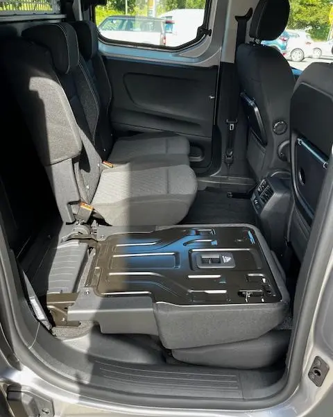 Vue intérieure côté droit du Peugeot Rifter gris foncé 2024, siège arrière droit partiellement rabattu montrant la structure métallique.