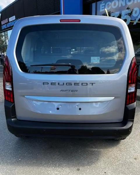 Vue arrière d'un Peugeot Rifter gris foncé 2024 avec lunette arrière large et feux arrière verticaux rouges.