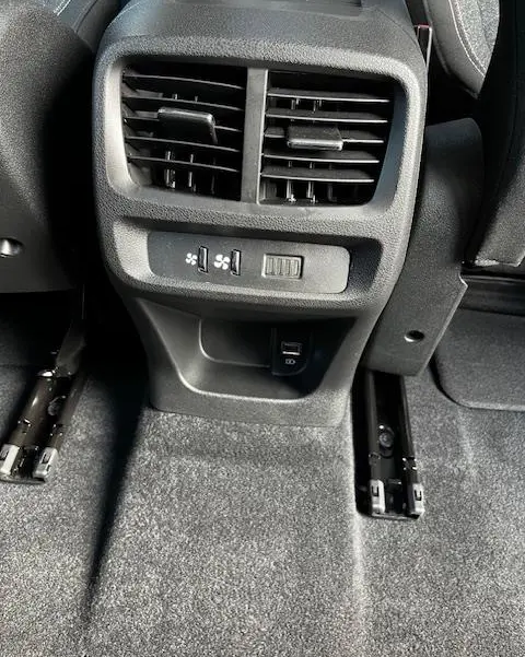 Vue rapprochée des aérateurs arrière et commandes de ventilation avec prise USB dans un Peugeot Rifter gris foncé 2024.