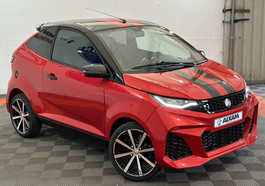 Vue 3/4 avant droite de l'AIXAM AMBITION rouge 2026 avec bandes noires sur capot et jantes alliage noires.