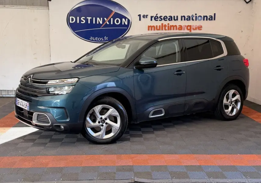 Vue 3/4 avant droit du Citroën C5 Aircross Hybrid bleu avec jantes alliage et signature lumineuse LED distinctive.