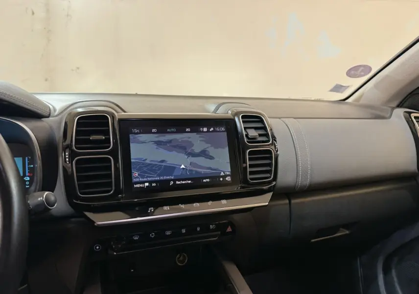 Vue intérieure du tableau de bord du Citroën C5 Aircross Hybrid bleu, avec écran tactile central affichant la navigation.